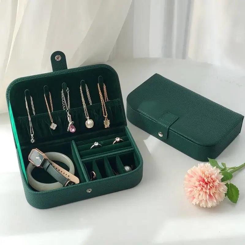 Coffret à bijoux vert ouvert, avec un second coffret fermé à côté.